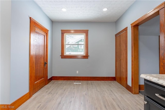 interior space featuring light hardwood / wood-style flooring and a textured ceiling