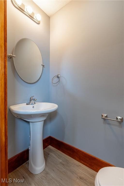 bathroom featuring hardwood / wood-style flooring and toilet