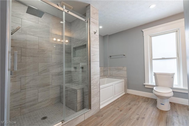 bathroom featuring wood-type flooring, plus walk in shower, and toilet