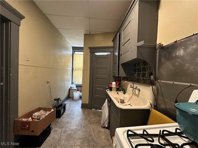 interior space featuring a paneled ceiling and range with gas stovetop