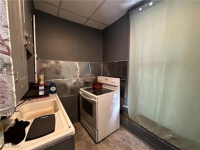 kitchen featuring a paneled ceiling, tile walls, and electric stove