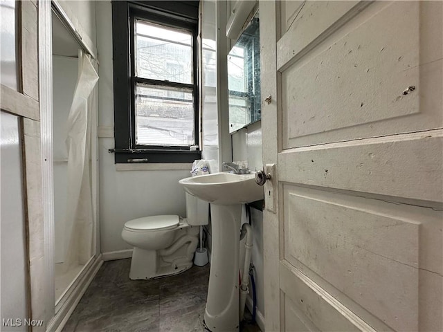 bathroom featuring curtained shower and toilet