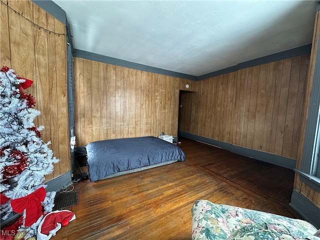 bedroom with dark hardwood / wood-style flooring and wood walls