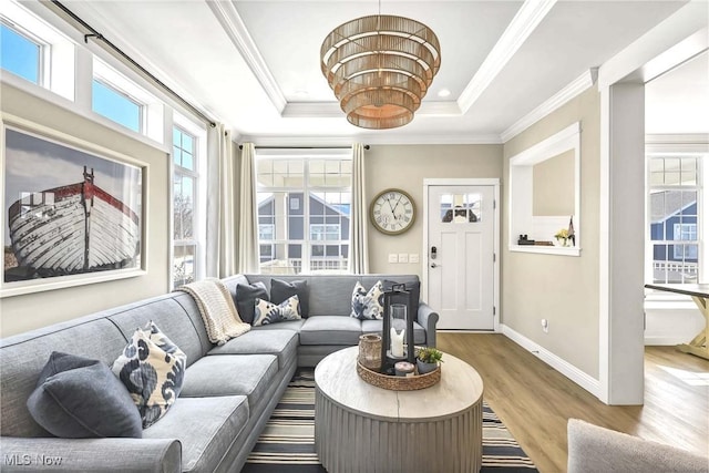 living room with a raised ceiling, crown molding, and hardwood / wood-style floors