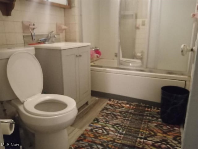 full bathroom featuring bath / shower combo with glass door, wood-type flooring, vanity, and toilet