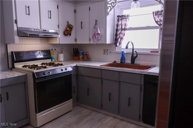 kitchen featuring range with gas stovetop, sink, gray cabinetry, white cabinets, and light hardwood / wood-style floors