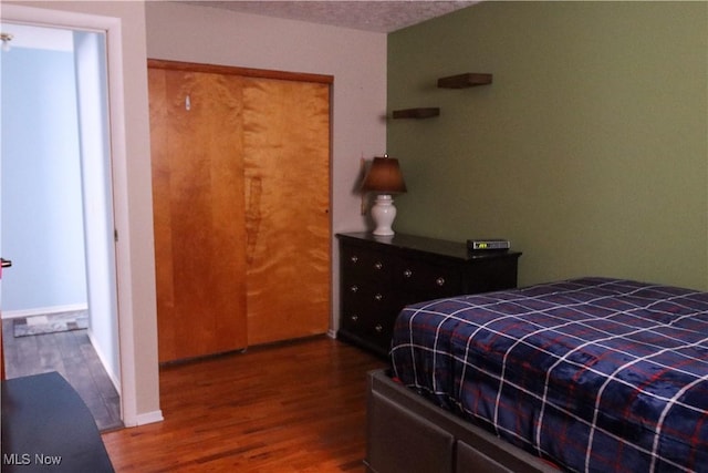 bedroom with hardwood / wood-style floors and a closet