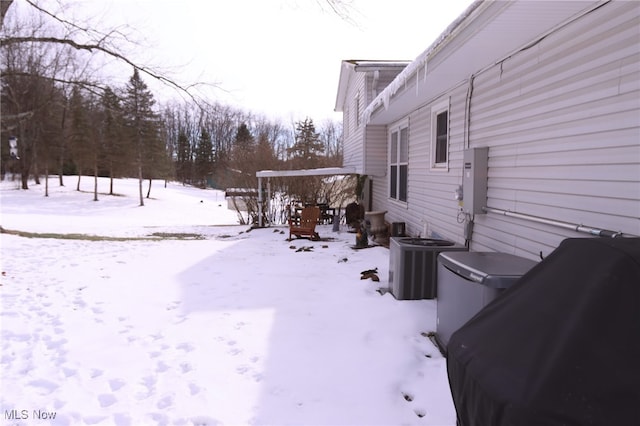 snowy yard featuring central air condition unit