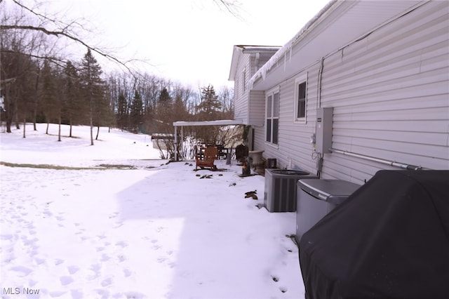 yard covered in snow featuring central AC unit