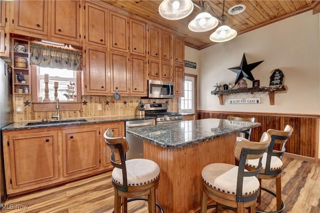 kitchen with decorative light fixtures, sink, a center island, stainless steel appliances, and wooden ceiling