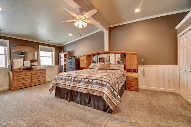 carpeted bedroom featuring ornamental molding, ceiling fan, and a closet