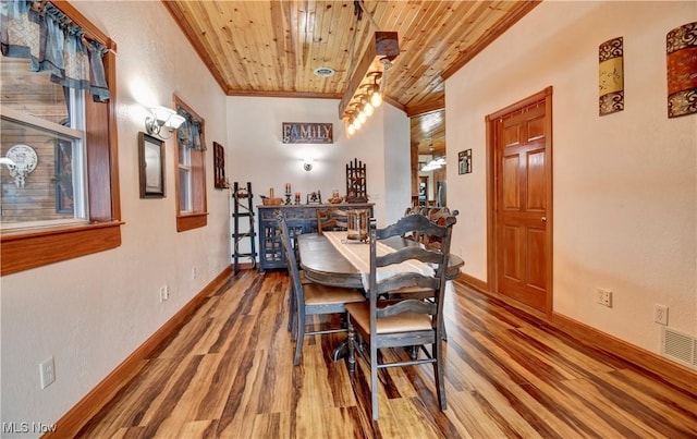 dining space with ornamental molding, wood-type flooring, and wooden ceiling