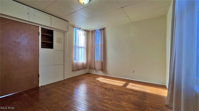 unfurnished room featuring hardwood / wood-style floors and a drop ceiling