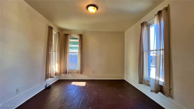 empty room with dark hardwood / wood-style flooring