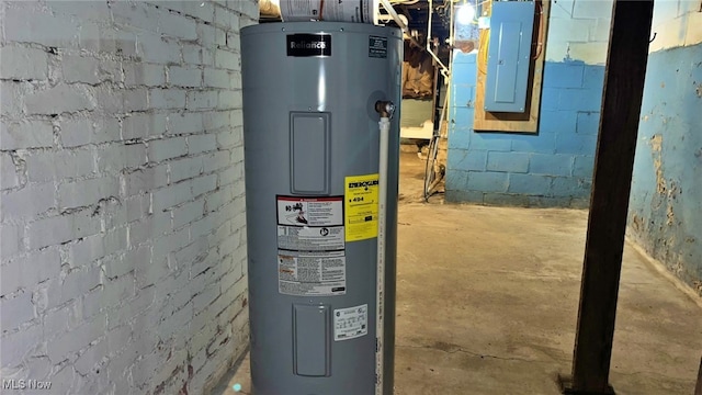 utility room featuring electric panel and water heater