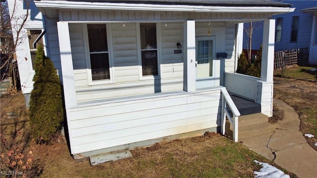 view of side of property featuring covered porch