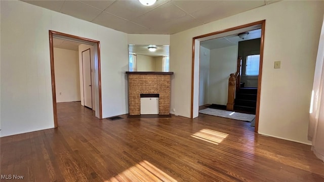 unfurnished living room featuring dark hardwood / wood-style flooring and a fireplace