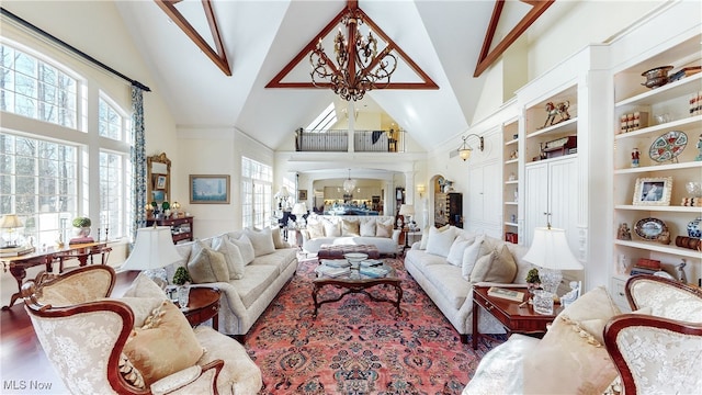 living room with wood-type flooring, high vaulted ceiling, built in features, and an inviting chandelier