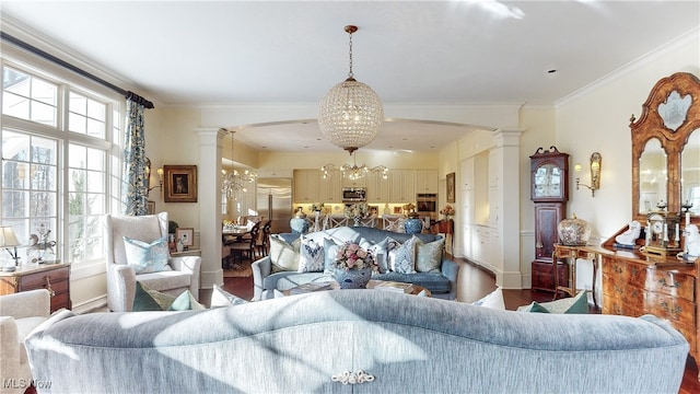 living room featuring decorative columns, hardwood / wood-style flooring, and an inviting chandelier