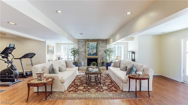 living room with hardwood / wood-style flooring and a brick fireplace