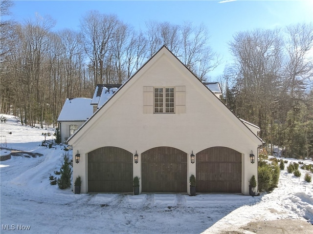 view of snow covered exterior with a garage