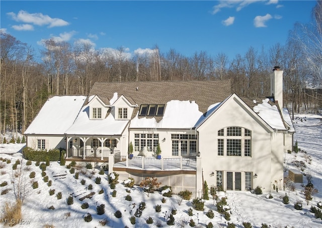 view of snow covered rear of property