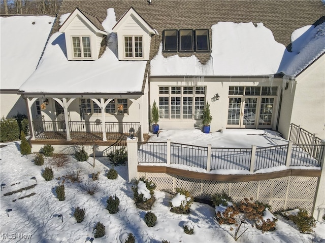 view of snow covered rear of property