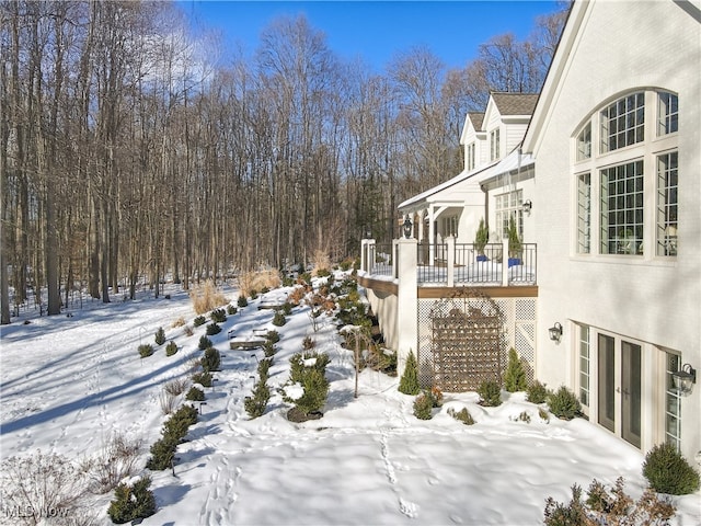 yard covered in snow featuring a wooden deck