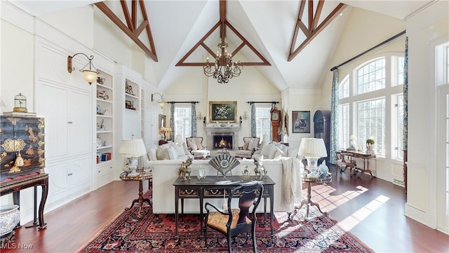 living room featuring dark hardwood / wood-style flooring, a chandelier, high vaulted ceiling, and built in features