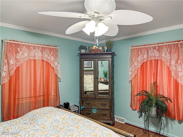 bedroom with crown molding, wood-type flooring, and ceiling fan