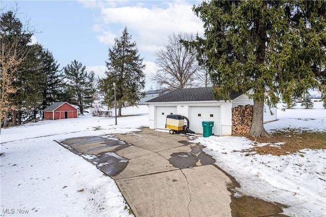 yard covered in snow with an outbuilding and a garage