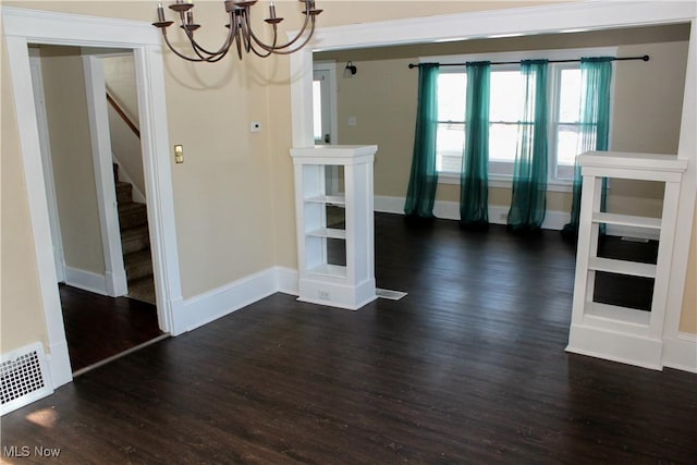 unfurnished dining area featuring dark hardwood / wood-style flooring and a notable chandelier