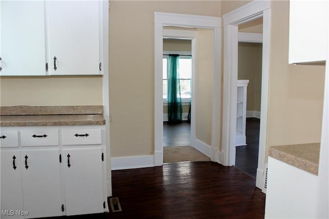 kitchen with dark hardwood / wood-style floors and white cabinets