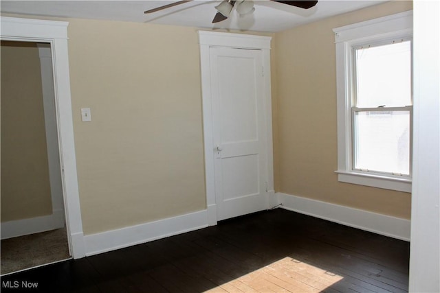 unfurnished room featuring a wealth of natural light, dark wood-type flooring, and ceiling fan