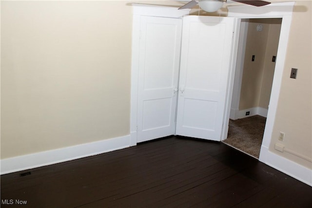 unfurnished bedroom with dark wood-type flooring and ceiling fan