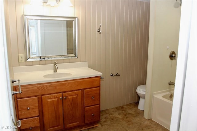 bathroom with vanity, a tub to relax in, and toilet