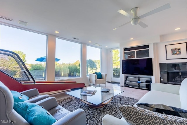 living room with light tile patterned floors and floor to ceiling windows