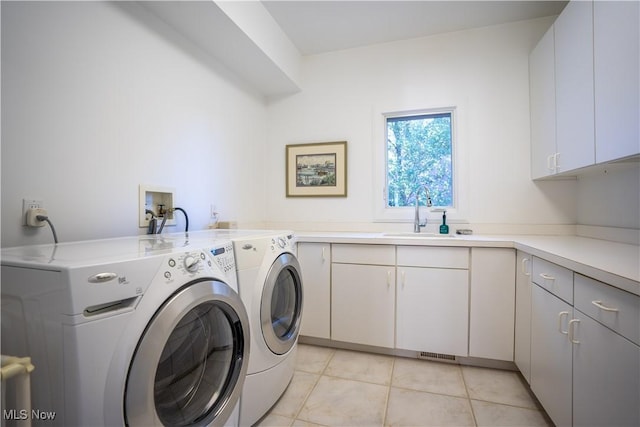 washroom featuring light tile patterned flooring, cabinets, separate washer and dryer, and sink