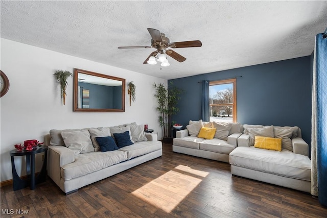 living room featuring ceiling fan, a textured ceiling, and dark hardwood / wood-style flooring