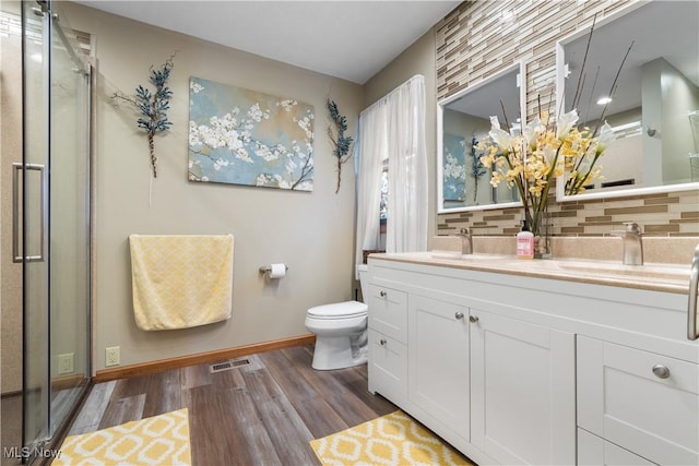 bathroom with tasteful backsplash, vanity, a shower with door, and hardwood / wood-style floors