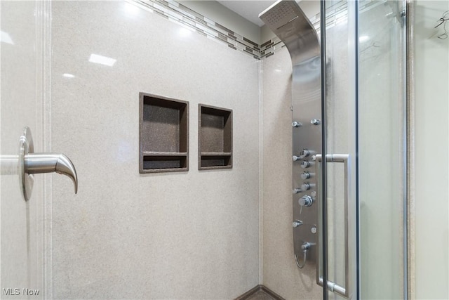 bathroom featuring a shower with door