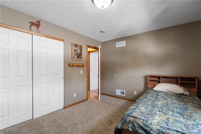 bedroom featuring carpet floors, a textured ceiling, and a closet