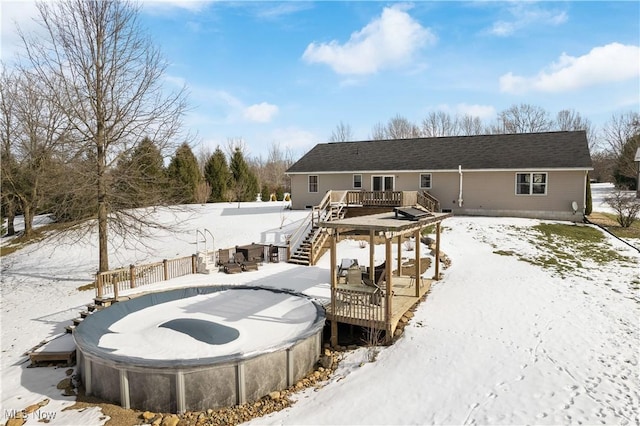 snow covered house with a wooden deck