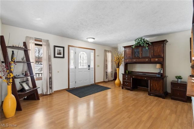 entryway with a textured ceiling and light hardwood / wood-style flooring