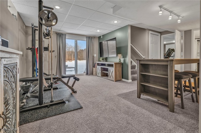 workout area featuring a paneled ceiling, rail lighting, and carpet floors