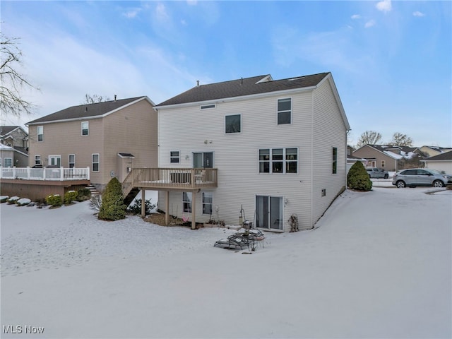 snow covered property with a wooden deck