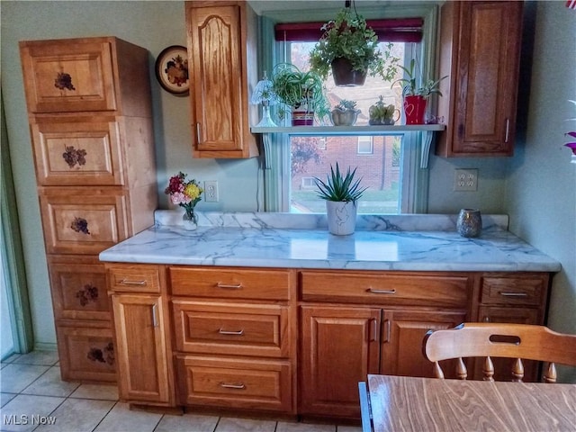 kitchen with light tile patterned flooring and light stone countertops