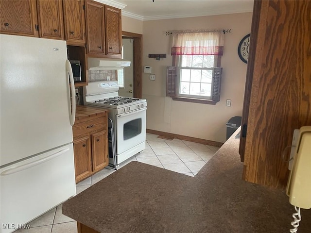 kitchen featuring white appliances, ornamental molding, and light tile patterned floors