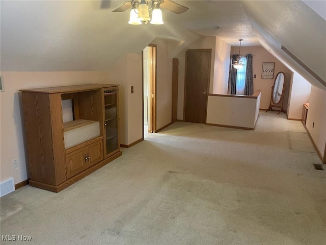 bonus room with lofted ceiling, light carpet, and ceiling fan