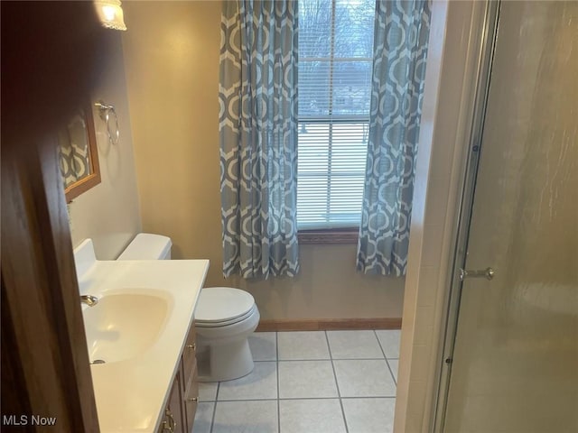 bathroom with vanity, tile patterned floors, toilet, and walk in shower